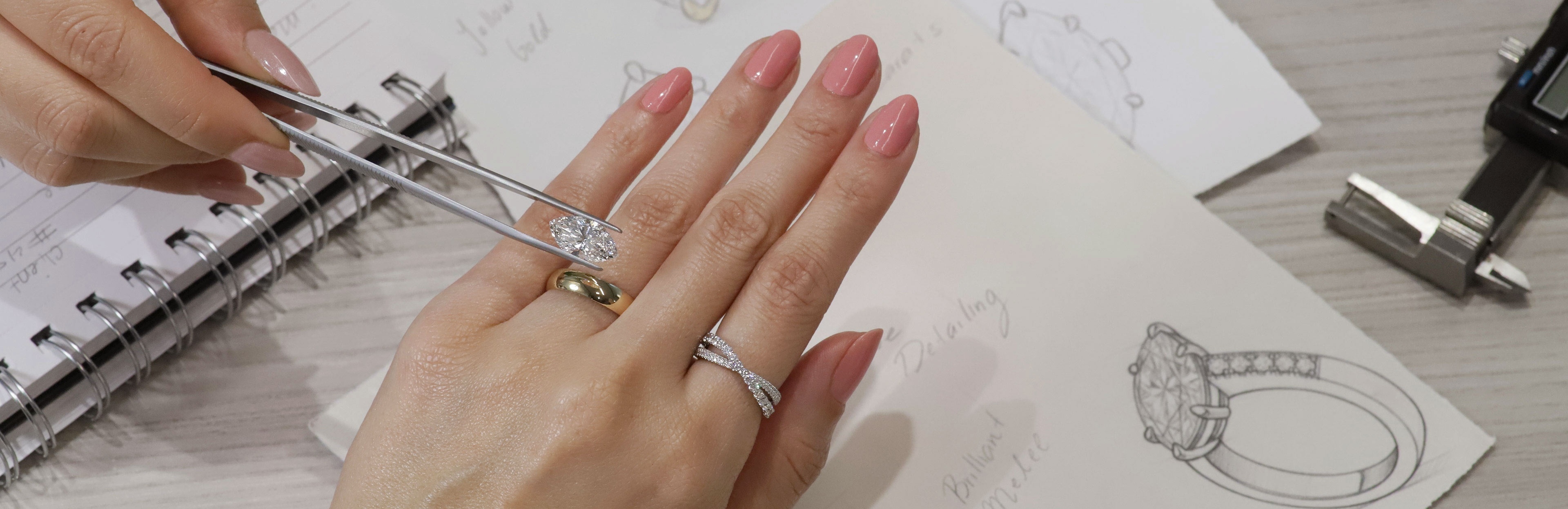 a designer placing a diamond over a band with ring sketches underneath