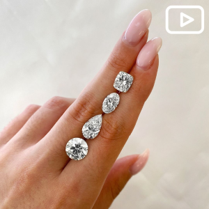 Loose Diamonds Between Woman's Fingers.